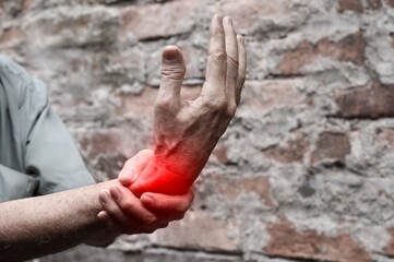 Inflammation of Asian man wrist joint. Concept of joint pain and hand problems.