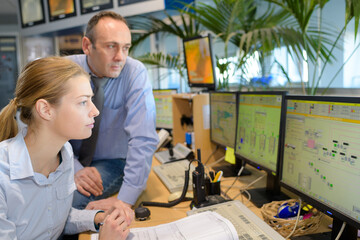 colleagues watching monitors in computer surveillance center