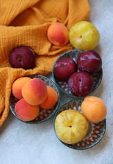 Apricots and plums on a table. Top view photo of fresh organic fruit. Fruit skin texture close up photo. Eating fresh concept. 