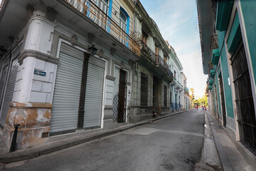 Street scene with classic old cars and traditional colorful buildings in downtown Havana.