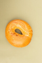 top view of single fresh baked bagel isolated on green background