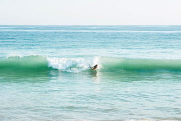 Person auf Wakeboard in Welle am Meer