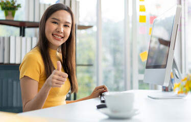 Portrait happy young programmer Asian woman work at start up technology office and using computer for coding application program and fully creative. Concept of smart entrepreneur woman working.