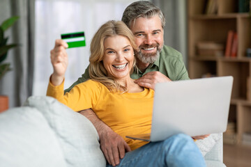Middle Aged Wife And Husband With Laptop And Credit Card At Home