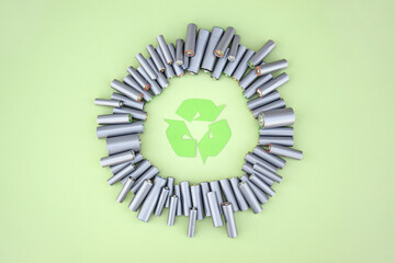 Used AA batteries and proper disposal of environmentally and soil toxic batteries on a green...
