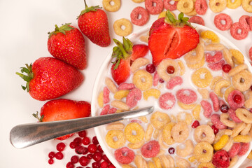 Quick breakfast of cereals and rings of corn and wheat with strawberries and lingonberries, top view.