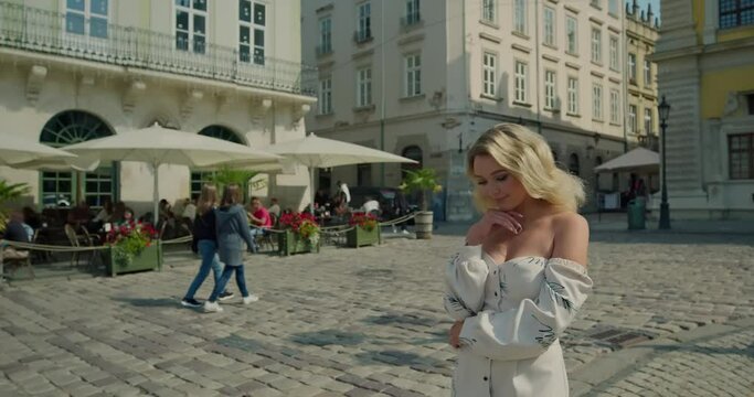 Beautiful girl in white dress walking streets in town
