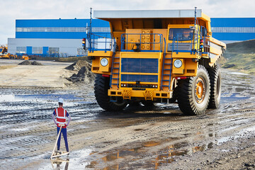 The dump truck, which is controlled remotely, works on the site and goes around the layout of a person © korsarid