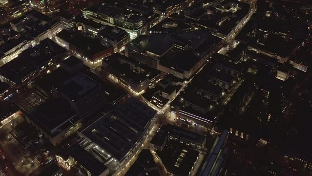 Fly above modern urban borough around Neumarkt. Illuminated buildings and streets at night. Cologne, Germany