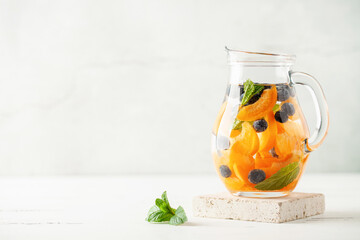 Detox infused water in glass. Refreshing summer homemade cocktail with fruit, berries and citrus
