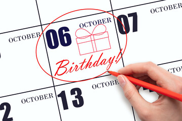 The hand circles the date on the calendar 6 October, draws a gift box and writes the text Birthday. Holiday.