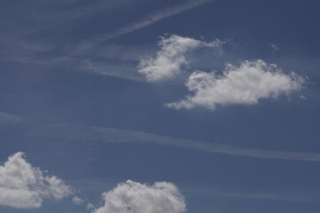 Blauer freundlicher Himmel mit wenigen Wolken, Zieren und Kondensstreifen