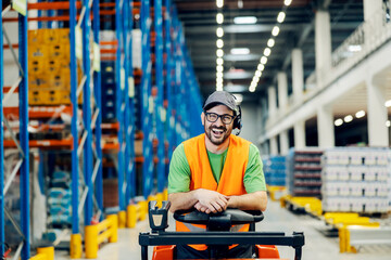 A storage worker posing on forklift and smiling at the camera.
