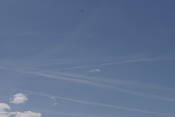 Blauer freundlicher Himmel mit wenigen Wolken, Zieren und Kondensstreifen
