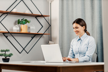 An entrepreneur at the home office works on a laptop.