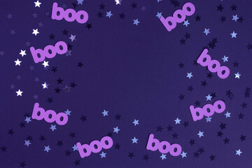 Cute Halloween Layout Border Made of Paper Cut Boo and Shrimmering Silver and Black Confetti of Star Shape on a Dark Violet Background. Halloween Flat Lay ideal for Card, Banner, Invitation, Poster.