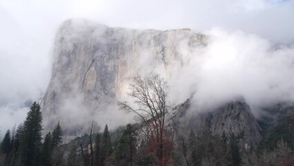 Foggy El Capitan mountain, cliff or steep rock, misty autumn weather, Yosemite valley, California, USA. Scenic crag, bluff and fall forest. Brume or haze clouds timelapse. Seamless looped cinemagraph.