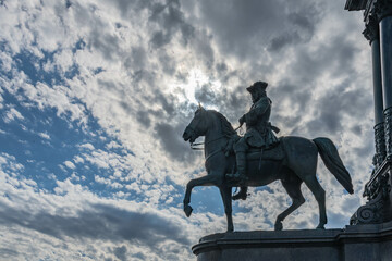 Reiterstatue vor dramatischem Wolkenhimmel