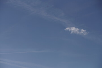 Blauer freundlicher Himmel mit wenigen Wolken, Zieren und Kondensstreifen