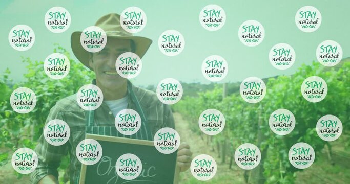 Animation of stay natural text over happy caucasian male farmer