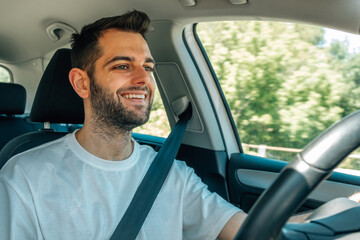 young man behind the wheel of the car driving