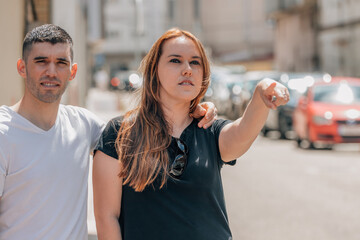 travel man and woman couple pointing on the street