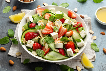 Summer Strawberry, cucumber salad with lettuce, feta cheese and almonds. Healthy Food.