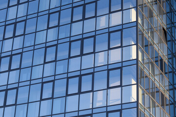 Fototapeta na wymiar Glass office building, view of the sky reflected in the windows. Concept for work, business, offices. Copy space