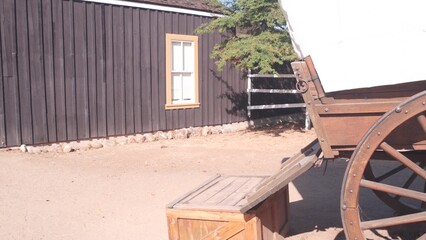 Old wooden retro covered wagon on wheels, wild west pioneer ranch. Western historic retro cart,...