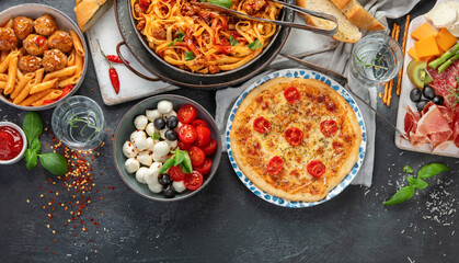 Italian food assortment on dark background.