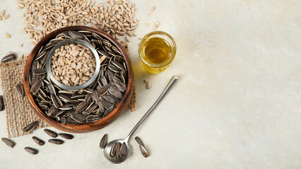 Sunflower oil and sunflower seeds on light background.