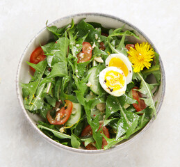 Fresh dandelion salad on light background.