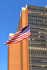 American flag on background of James A. Byrne United States Courthouse, Federal courthouse in Center City region of Philadelphia