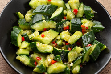 Asian Chinese Smashed beaten Cucumber salad, pai huang gua, in a black bowl