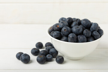 Blueberries in a ceramic bowl on a light textured background. Ripe and fresh blueberries. Vitamins. Healthy food. Juicy berry.Copy space.Place for text