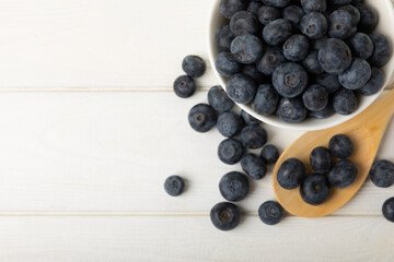 Blueberries in a ceramic bowl on a light textured background. Ripe and fresh blueberries. Vitamins. Healthy food. Juicy berry.Copy space.Place for text