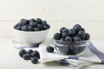 Blueberries in a ceramic bowl on a light textured background. Ripe and fresh blueberries. Vitamins. Healthy food. Juicy berry.Copy space.Place for text