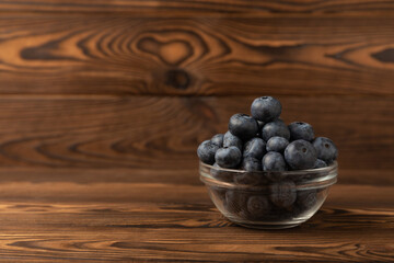 Blueberries in a ceramic bowl on a brown textural background. Ripe and fresh blueberries. Vitamins. Healthy food. Juicy berry.Copy space.Place for text