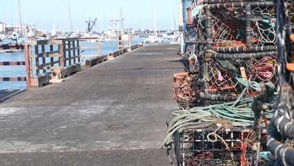 Traps, ropes and cages on pier, commercial dock, fishing industry, Monterey California USA. Empty pots, creels for fish seafood catching in port. Many fisherman's nets and baskets in seaport. Fishery. - obrazy, fototapety, plakaty