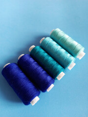 threads for sewing in blue colors on a light blue background