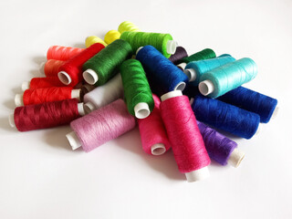 colored threads for sewing on a white background