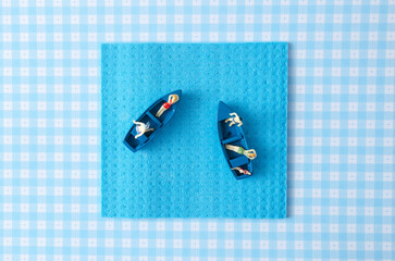A blue sponge with mini people  sunbathing in two blue boat. Surreal minimal concept for summer...
