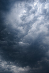 Dark rainy twisted thunderstorm clouds grey color vertical image