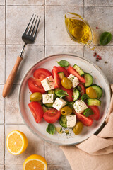 Greek salad. Fresh Greek salad with fresh vegetables, tomato, cucumber, green olives and feta cheese on old grey concrete table background. Top view.