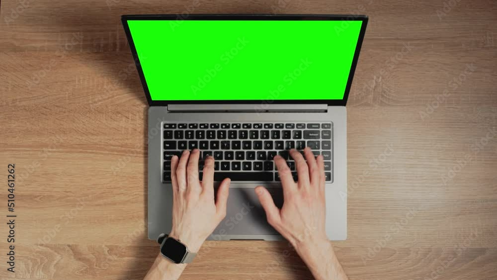 Poster closeup a man hands are typing on laptop keyboard with green screen. place for pasting content on ch