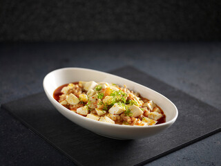 Ma Po Tofu with Prawns served in a dish isolated on mat side view on grey background