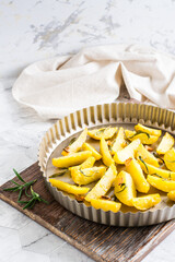 Baked potatoes with garlic and rosemary in a pan. Homemade vegetarian dish. Vertical view