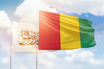 Sunny blue sky and flags of guinea and afghanistan