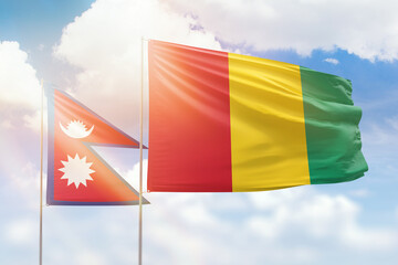 Sunny blue sky and flags of guinea and nepal