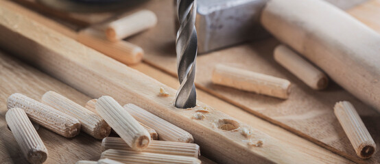 drill bit, hammer, dowel and rasp on wooden oak board